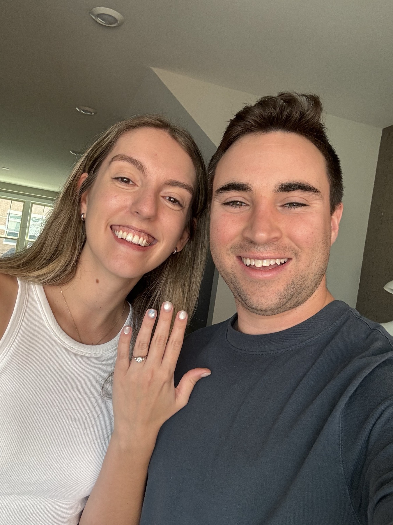 Caitlin and Paul celebrating their engagement with ring